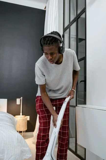 services-01 Cleaner using a vacuum in a stylish indoor setting, showcasing cleaning equipment and techniques.